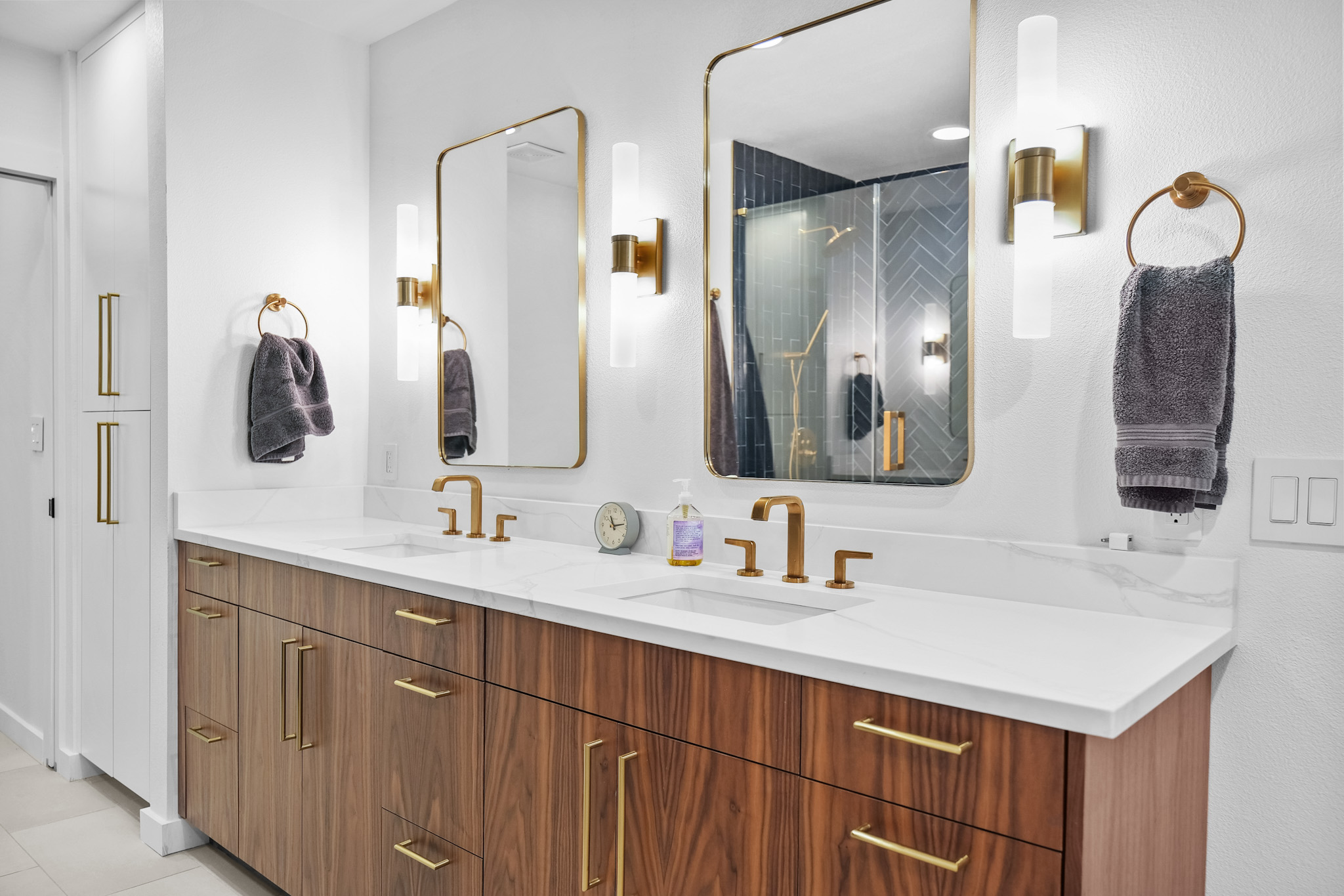 Master bathroom with walnut vanity and gold fixtures